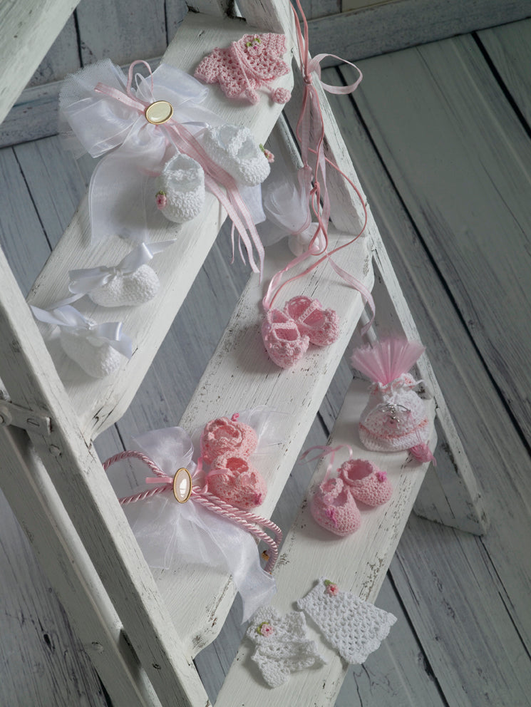 Μπομπονιέρες χειροποίητα πλεκτά παπουτσάκια, ζιπουνάκια και πουγκί σε λευκές και ρόζ αποχρώσεις.