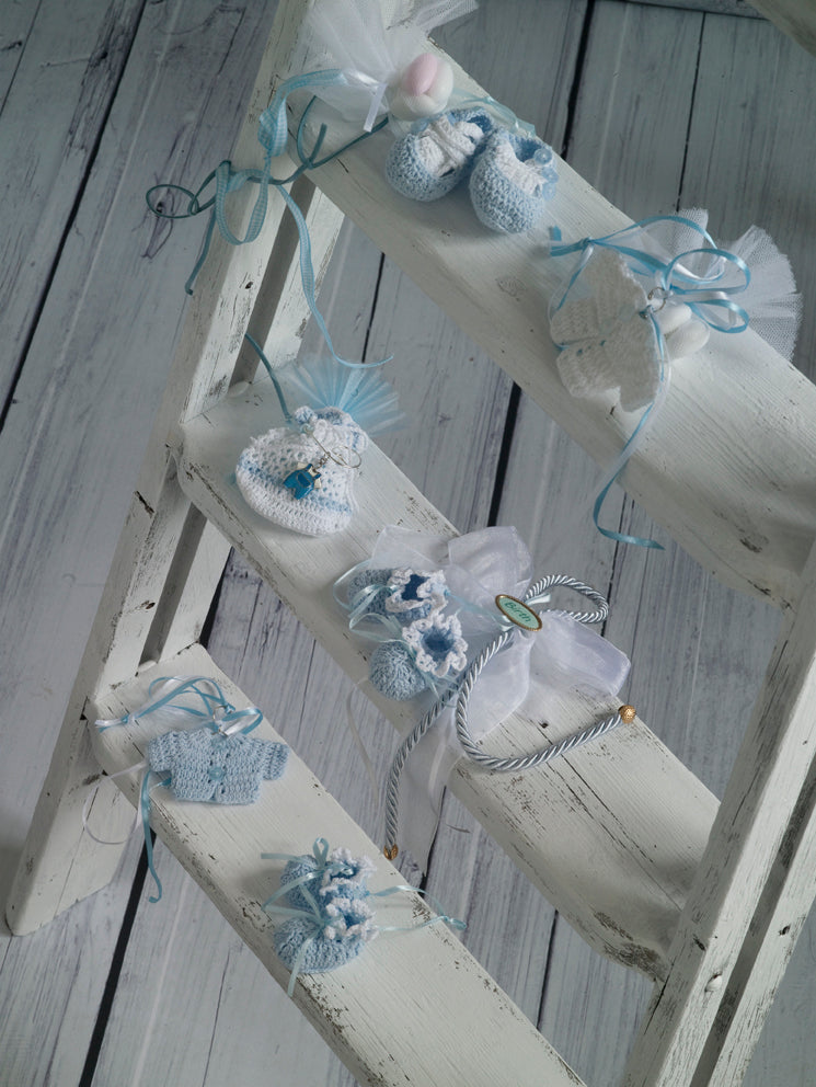 Μπομπονιέρες χειροποίητα πλεκτά παπουτσάκια, ζιπουνάκια και πουγκί σε λευκές και σιέλ αποχρώσεις.